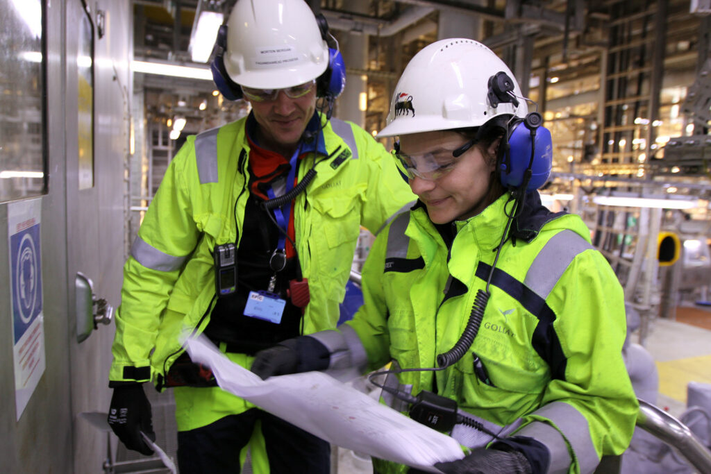 To ansatte på Goliat som ser på et dokument.