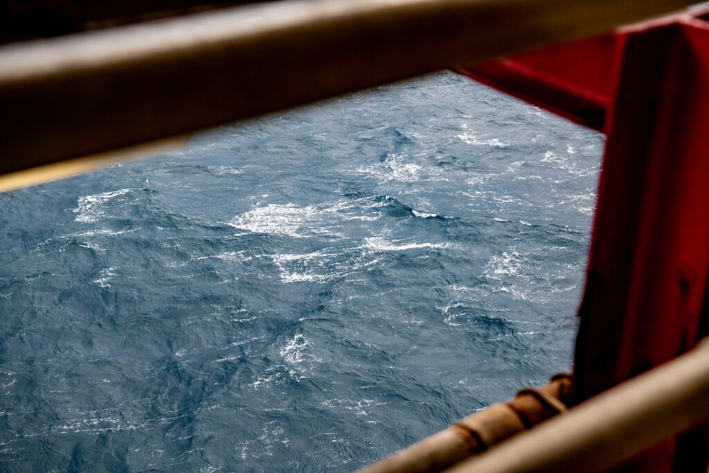 Downwards view of the ocean from an oil rig deck