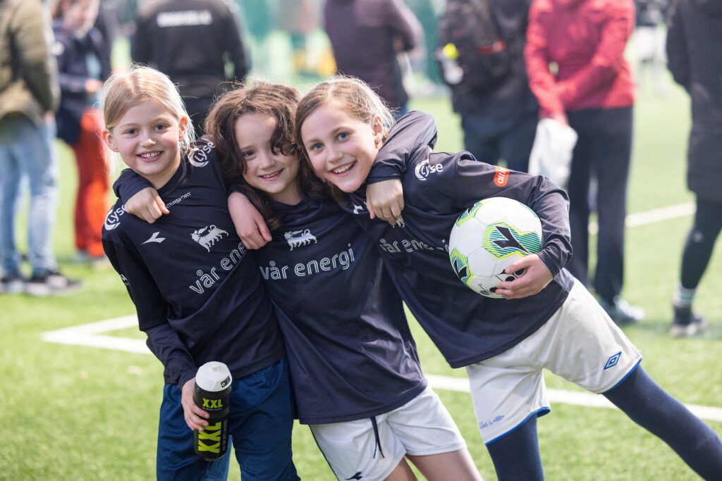 Three girls in football jerseys